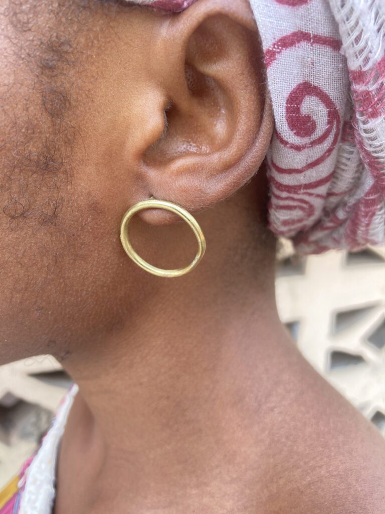 woman wearing single loop brass earrings